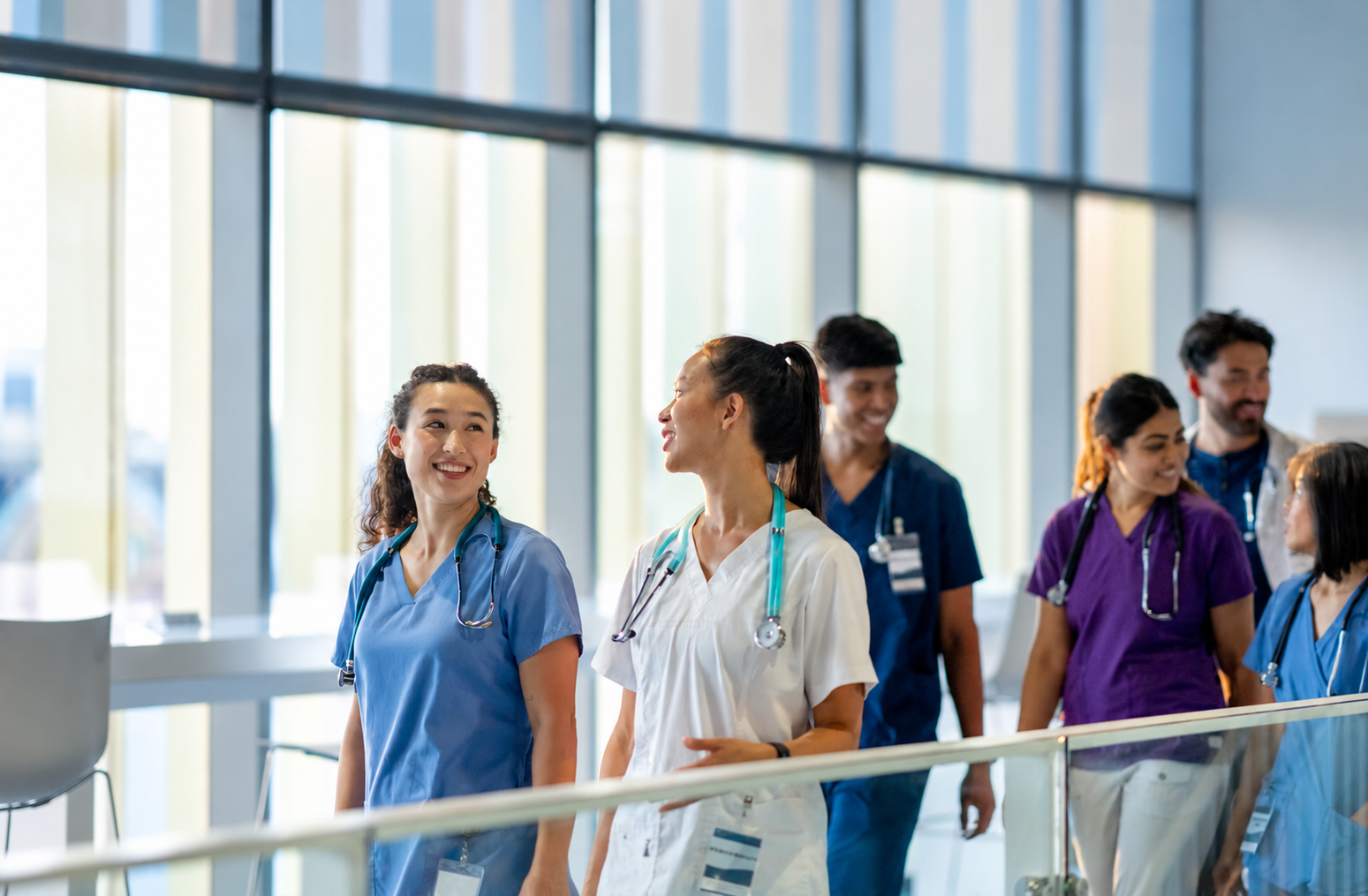 Doctors in scrubs walking and talking together in a hospital corridor